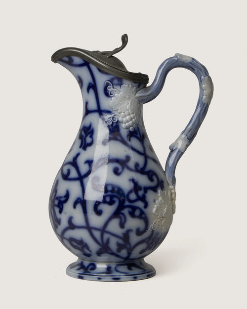 Beautiful late 19th-century antique relief-molded ceramic jug featuring a classic blue and white design and original pewter lid.