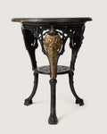 Late 19th-century Victorian bistro table featuring a heavy ornate cast iron base with gilded masks and a solid wood top.