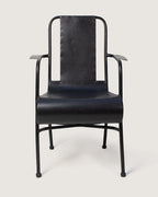 Vintage 1950s industrial medical chair in black enameled metal, expertly restored and repurposed for eclectic outdoor seating. One-of-a-kind vintage design curated by Atelier Bellinzona.