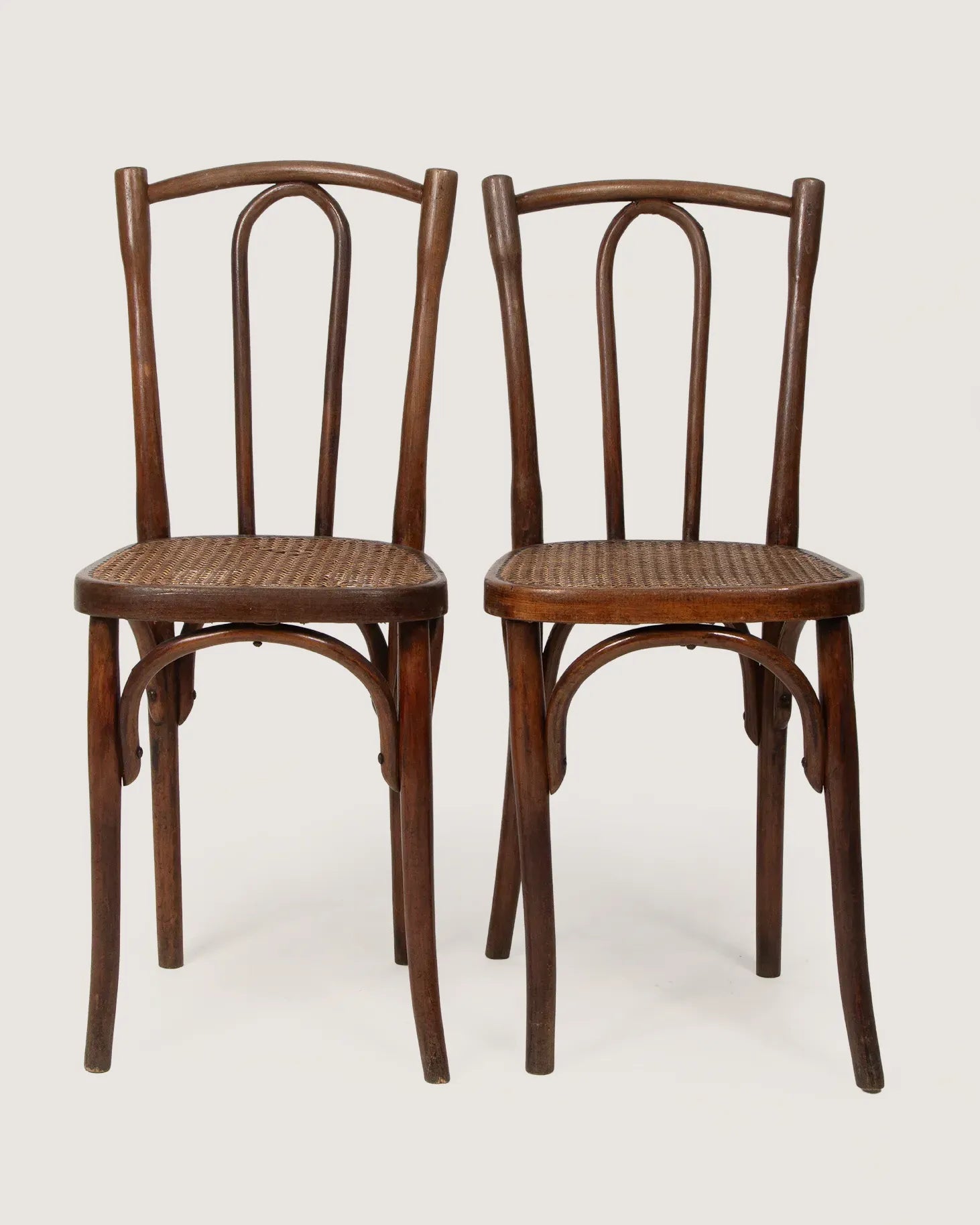 Pair of antique 1920s bentwood bistro chairs in the classic Thonet style, showing a beautifully weathered rich wood patina.