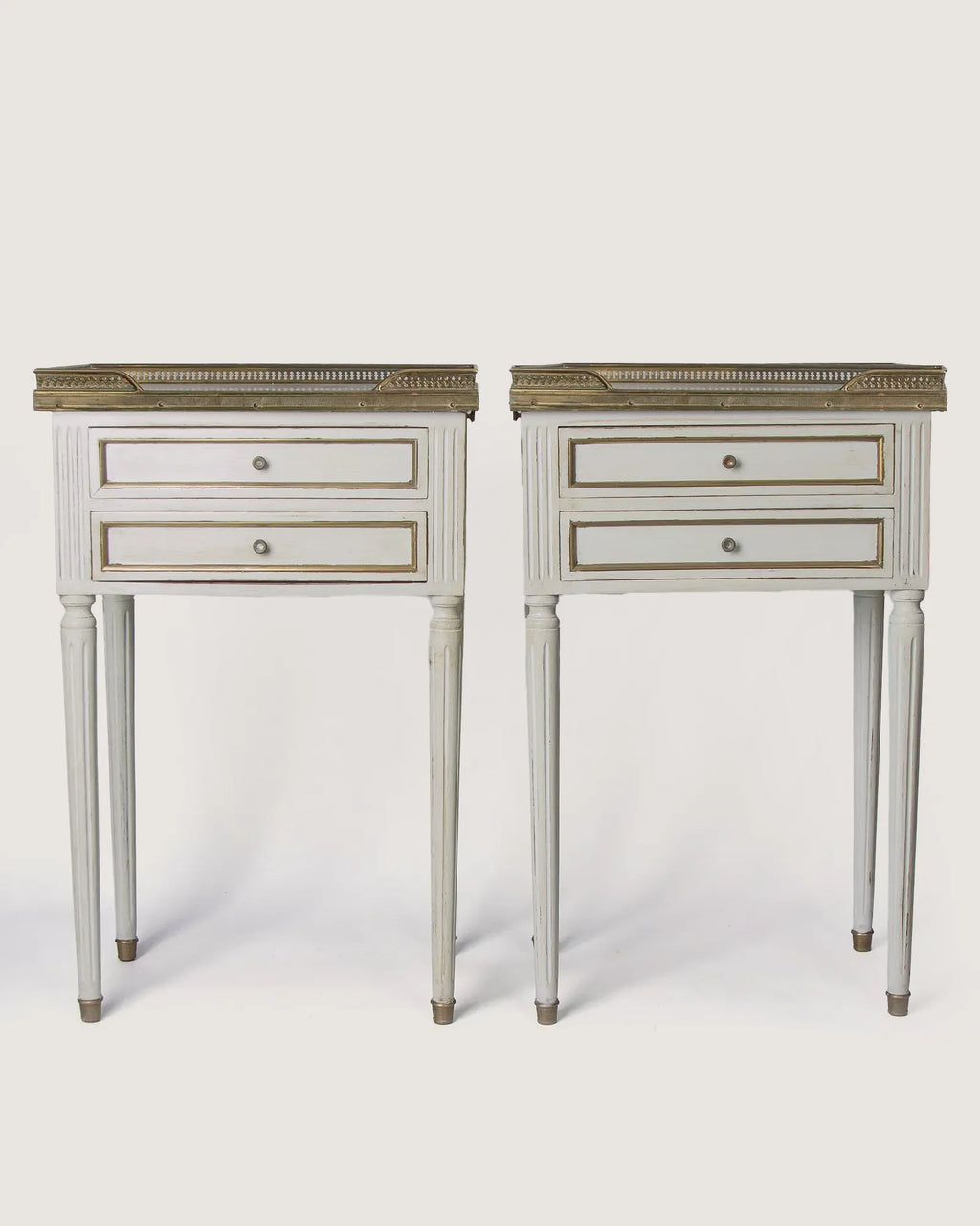 Full front studio view of the matching pair of Louis XVI style lacquered bedside tables standing symmetrically side by side.
