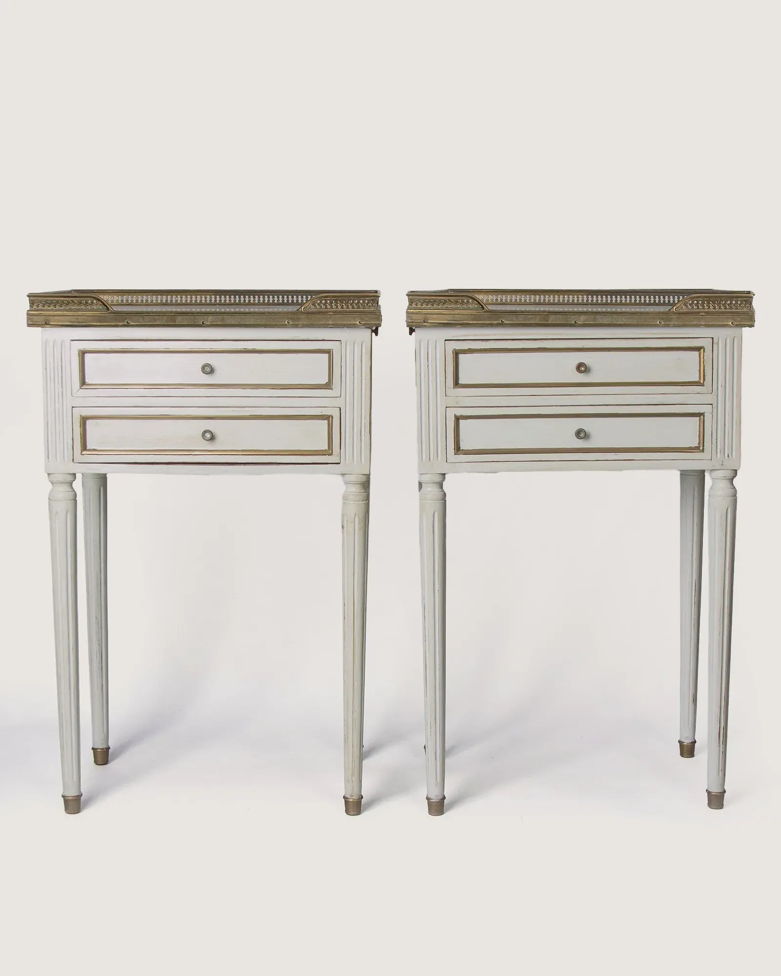 Full front studio view of the matching pair of Louis XVI style lacquered bedside tables standing symmetrically side by side.