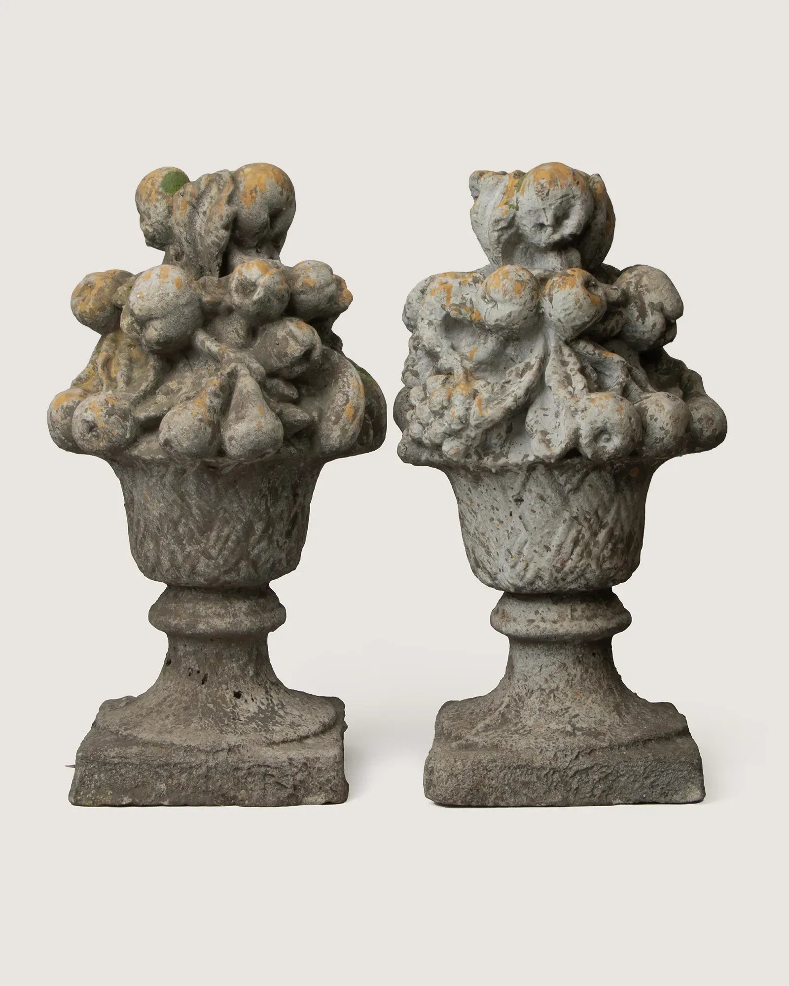 Pair of late 19th or early 20th-century stone and concrete gate trophies depicting heavily detailed baskets of fruit.