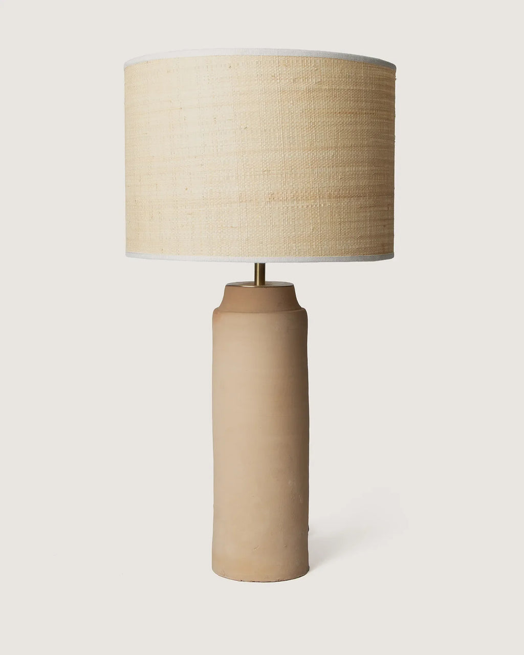 Wabi-sabi style raw Apulian terracotta table lamp featuring a handcrafted organic natural fiber lampshade.