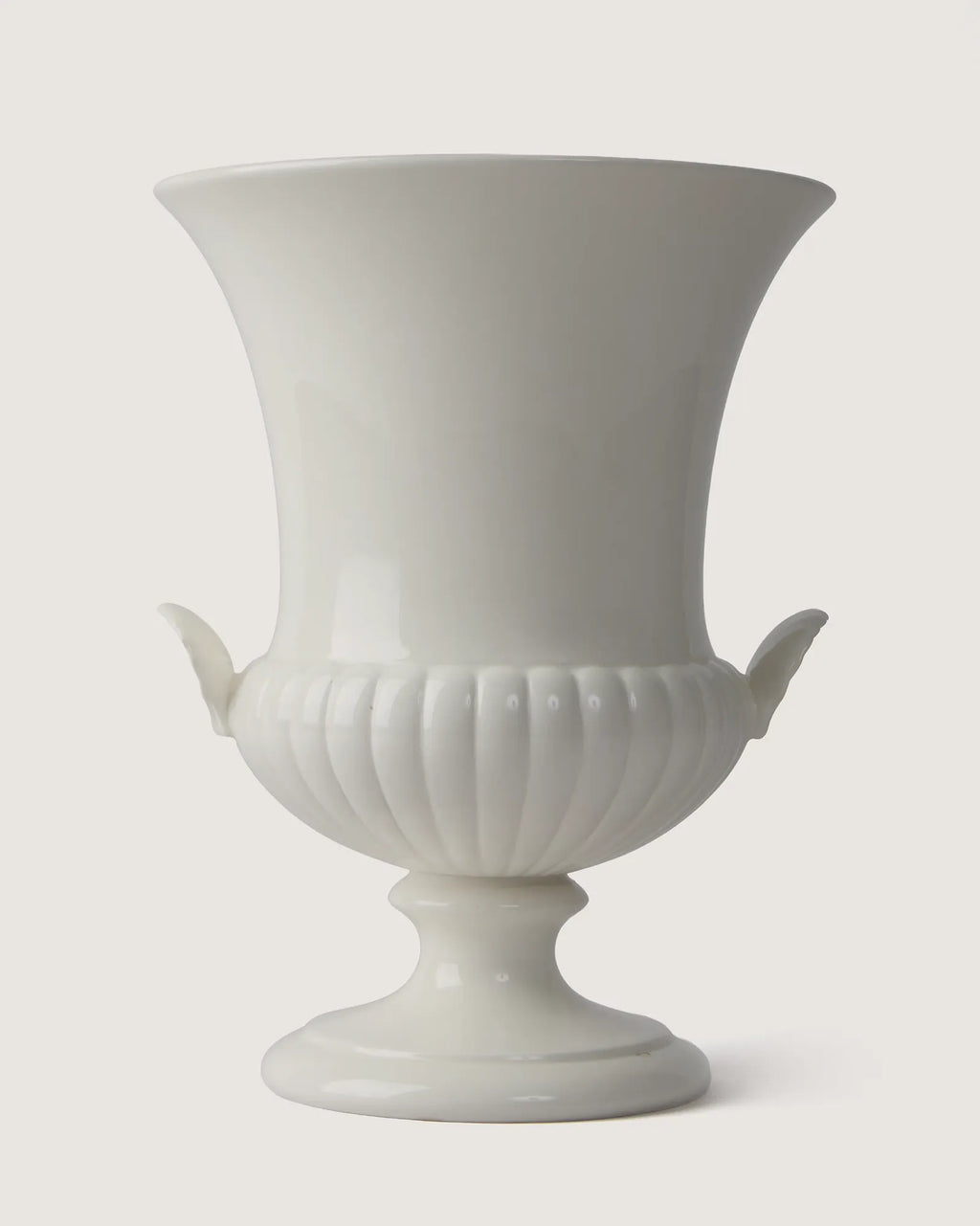 Full front view of the monochrome white Wedgwood glazed vase, highlighting its trumpet silhouette and matching side shell handles.