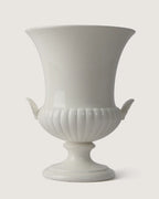 Full front view of the monochrome white Wedgwood glazed vase, highlighting its trumpet silhouette and matching side shell handles.
