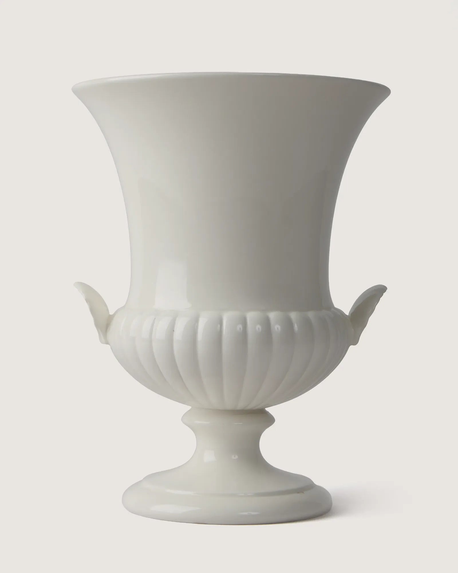 Full front view of the monochrome white Wedgwood glazed vase, highlighting its trumpet silhouette and matching side shell handles.